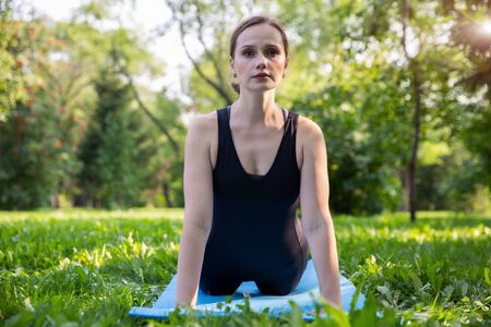 Beautiful woman doing Pilates in the green parkの写真素材