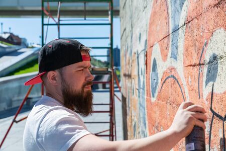 Graffiti artist painting with aerosol spray bottleの写真素材