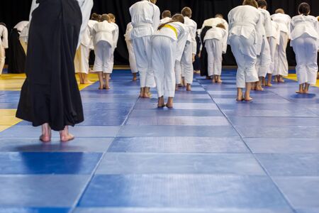 People in kimono warming up on tatami on martial arts training seminarの写真素材