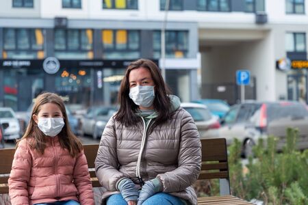A mother and her daughter put protective masks onの写真素材