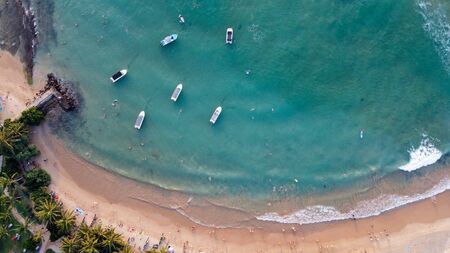 Boats docked in the blue lagoon near the tropical beachの写真素材