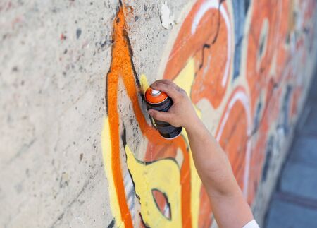 Graffiti artist painting with aerosol spray bottleの写真素材