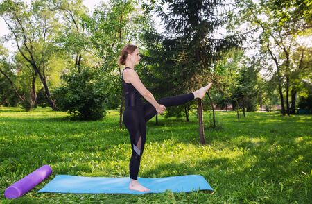Beautiful woman doing Pilates in the green parkの写真素材