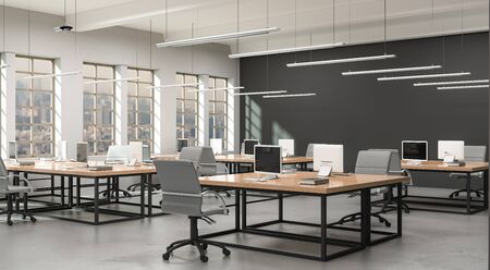 Side view of a modern office with a grey wall. Rows of tables, equipped workstations. 3d rendering.の写真素材
