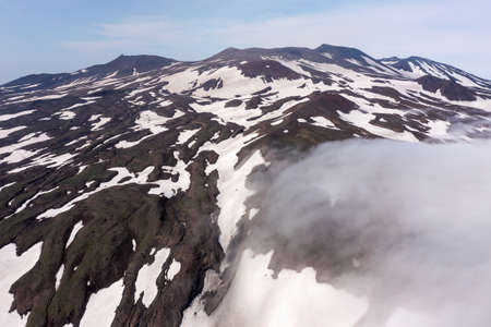 Aerial drone photo of the Gorely Volcano peaks rising above the fog. Kamchatka, Russiaの写真素材