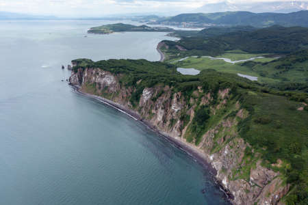 Aerial drone photo of Mayachny Cape on Kamchatka Peninsula on picturesque Avacha bay coast covered by green grass in the Pacific Oceanの写真素材