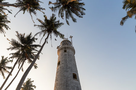 The old lighthouse of white stone located on the islandの写真素材