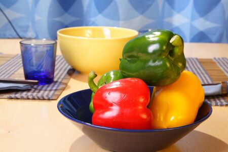 Colorful bell peppers on plate on a tableの写真素材