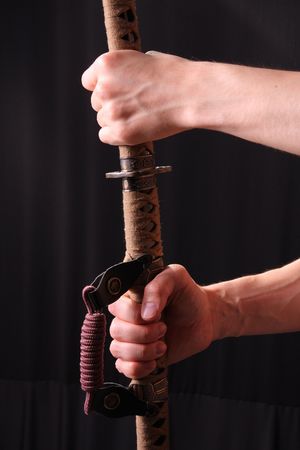 Closeup of man holding samurai sword in dramatic studio lightの写真素材