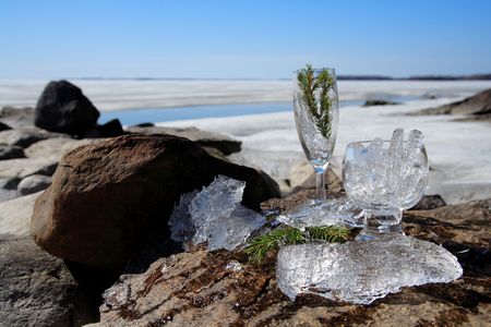 Glasses with ice on the edge of a frozen lakeの写真素材