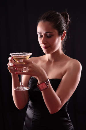 Beautiful young woman holding a martini glassの写真素材