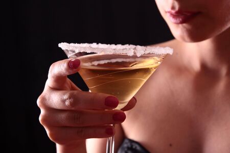 Beautiful young woman holding a martini glassの写真素材