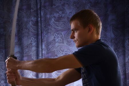 Studio portrait of young man and katanaの写真素材