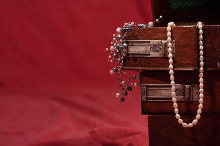 Beautiful antique wooden box filled with jewelsの写真素材