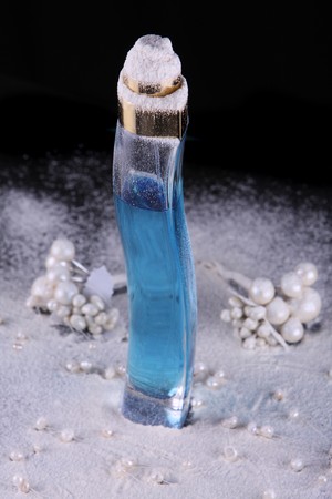 Tall perfume bottle with blue liquid in studio lightingの写真素材