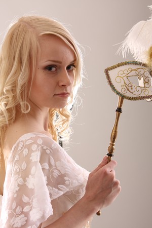 Beautiful young woman with Venetian mask, studio photoの写真素材