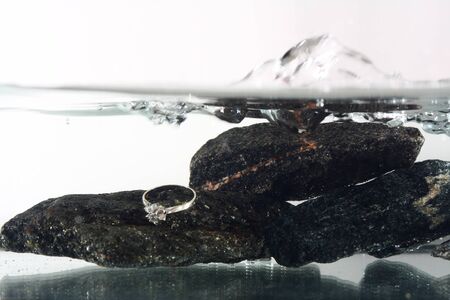 white gold ring underwater on black stonesの写真素材