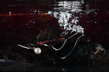 Necklace with white pearl underwater on black stonesの写真素材