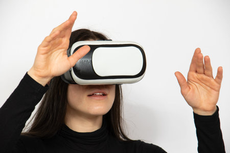 Caucasian woman portrait with virtual reality goggles on face. Studio shot with white blank...