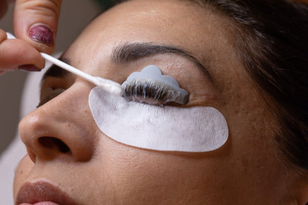 Close-up of a woman's face during an eyebrow thickening and eyelash lamination treatment. concept of...