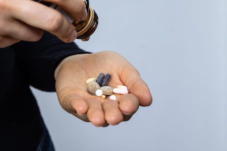 Drug abuse concept, hand of a woman with hypochondria problem pouring several pills