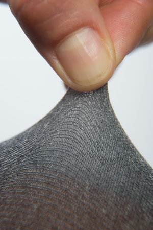Close up of woman finger pulling textile isolated on white. High-quality photo