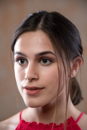 Close up portrait of a beautiful young woman with brown eyes looking at cameraの写真素材