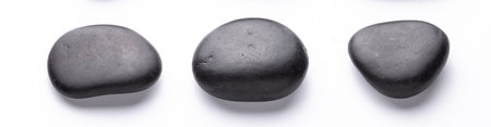 three black river pebbles arranged horizontally on a white background