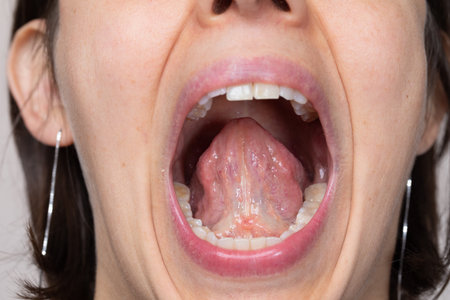 Close up of a woman's mouth with open mouth and tongue.