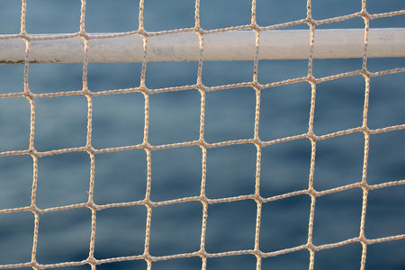 Close up of a white net on a yacht with sea in the backgroundの写真素材