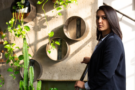 Young Arab entrepreneur in elegant dress and proud expression, inside the modern greenhouse of his start-up. Concept of innovation in the ecological and eco-sustainable fieldの写真素材