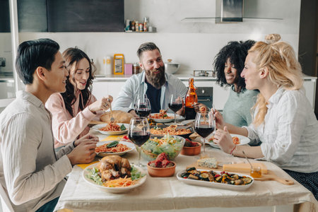 Happy group of friends having dinner party at home. Cheerful young people having lunch break...