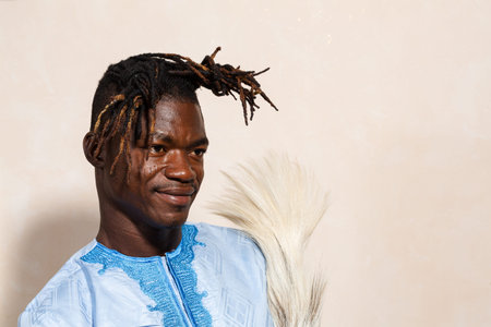 A profile shot of a confident African man donning traditional light blue attire with detailed...