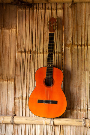 an iconic guitar rests against a reed wall, evoking the rich musical heritage and artisanal...