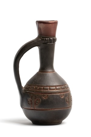 A small brown clay jug with patterns and a narrow high neck close-up view isolated on a white background.の写真素材