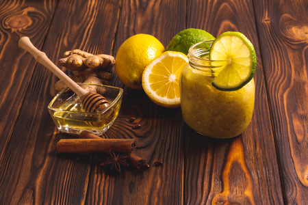 Ginger, lemon, honey, cinnamon on a dark wooden background. Cold cure recipe and healthy foodの写真素材