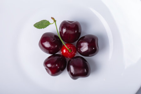 Ripe sweet cherries and one red cherry isolated on white background