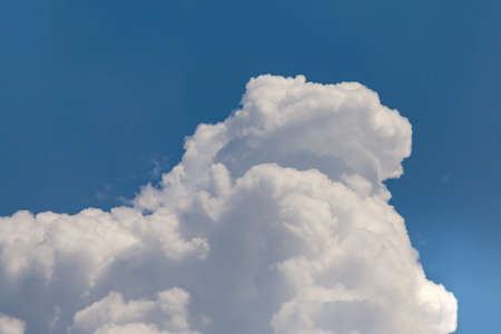 Huge cumulonimbus high in the deep blue skyの写真素材