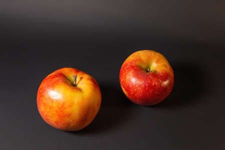 Two ripe whole red apples on a dark backgroundの写真素材