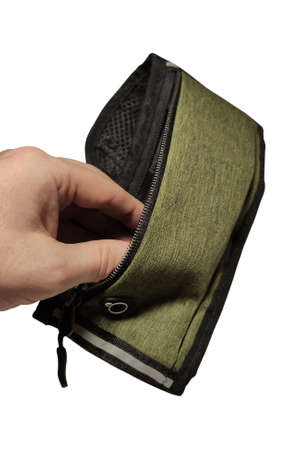 Man's hand opens an empty small sports waist bag isolated on white backgroundの写真素材