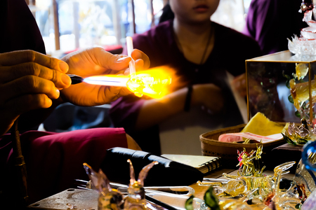 Glass artist in his workshop. Making glass beads in traditional styleの写真素材