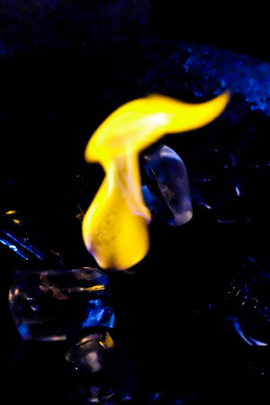 Burning ice cube on a shiny surface blue toneの写真素材