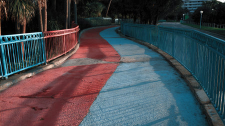 Gradient walkway transitioning from warm red tones to cool blue hues across the pathの素材