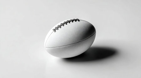 Rugby ball centered on a clean white surface, minimalist product layoutの素材