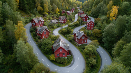 Forked road slicing through a green village dotted with traditional wooden housesの素材