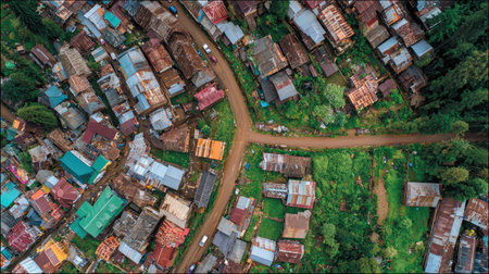 Top view of clustered homes with a narrow forked road dividing old wooden buildingsの素材