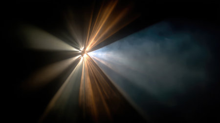 Abstract shot of light beams from a film projector slicing through darknessの素材