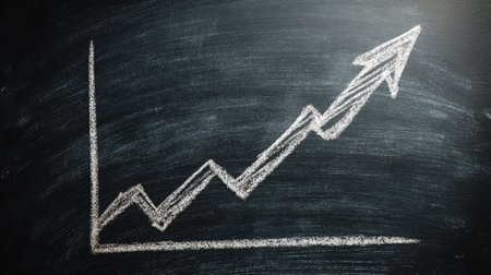 Simple hand-drawn graph on a chalkboard surface with a clear upward trend arrowの素材