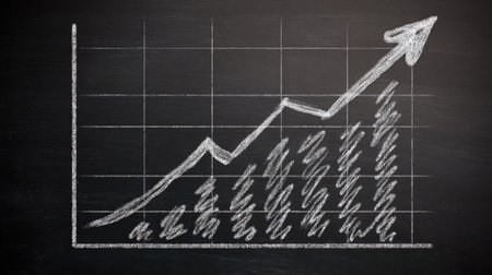Simple hand-drawn graph on a chalkboard surface with a clear upward trend arrowの素材