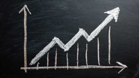 Simple hand-drawn graph on a chalkboard surface with a clear upward trend arrowの素材
